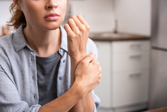 cropped view of woman touching hand at home