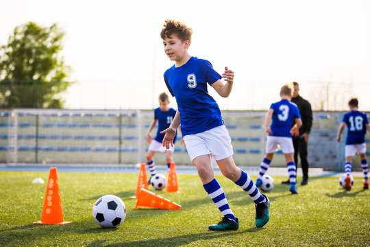 Kids Sports: Teaching Children To Improve Soccer Skills. Football Camp For  Kids. Boys Practice Dribbling In Field. Players Develop Skills. Children  Training With Balls And Cones. Soccer Slalom Drills Stock Photo |