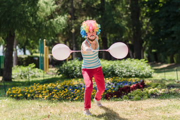 Mime performs in the park with balloons. Clown shows pantomime on the street.