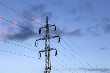 High voltage tower against the evening cloudy sky