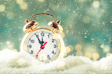 Christmas or New Year background with Golden alarm clock in snowdrifts on blue background with...