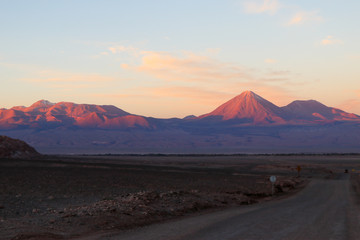 Northern Chile - San Pedro de Atacama and surrounding area - Valle de la Luna or Moon valley - this red rock landscape complete with sand dunes looks like a moon landing at sunset with red orange blue