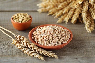 Bowls with wheat grains on light background.
Top view. Ears of wheat. Rustic style.
