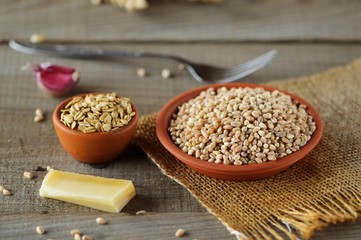 Wheat grain in dishes on the table.grains and wheat ears on a wooden table, top view