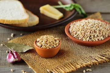 Wheat grain in dishes on the table.grains and wheat ears on a wooden table, top view