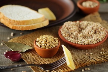 Wheat grain in dishes on the table.grains and wheat ears on a wooden table, top view