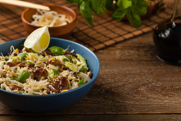 Fried veal, with rice, Chinese cabbage and mushrooms. Sprinkled with sesame and soy sauce.