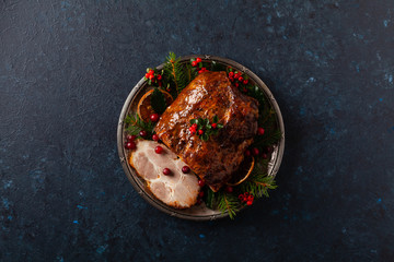Roast pork neck in Christmas style. Dark navy blue background. Christmas accessories. Top view.