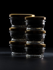 Glass jars with black sturgeon caviar.