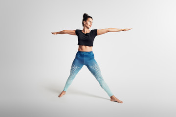 Fototapeta na wymiar Yoga basic warrior second pose, stretching, hands above head, woman on white backgroung, studio photos