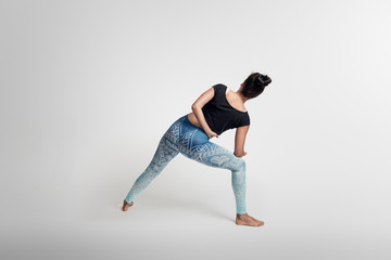 Yoga warrior pose from behinde, stretching, hands above head, woman on white backgroung, studio photos