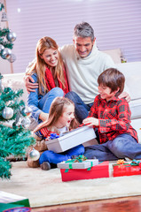 Holidays and celebration concept - Happy family at home celebrating Christmas day