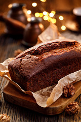 Homemade gingerbread on a baking paper on a rustic wooden table, close-up . Delicious dessert. - obrazy, fototapety, plakaty