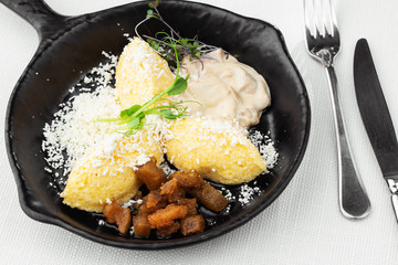 Typical Ukrainian dish polenta - Banosh with cheese, lard and white mushrooms. Maize porridge with...