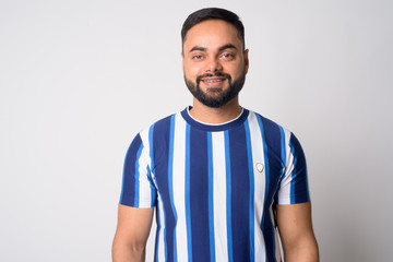Fototapeta premium Portrait of happy young bearded Indian man smiling
