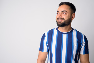 Fototapeta premium Face of happy young bearded Indian man thinking