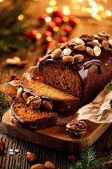 Christmas gingerbread cake covered with chocolate and decorated with nuts and almonds on the...