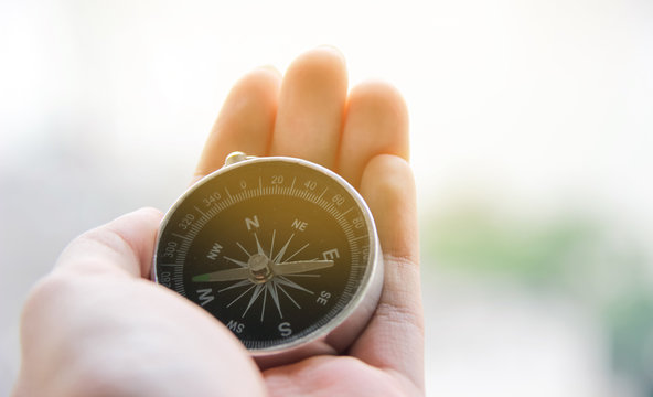 Hand holding a compass to guide the way, Compass business navigate, navigation of life