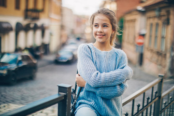 Little girl in an urban setting smiles at the camera.