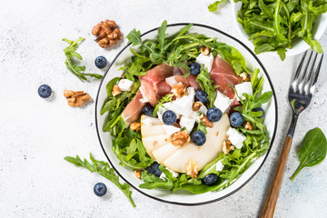 Green salad with leaves, fruit and jamon.