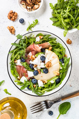 Green salad with leaves, fruit and jamon.
