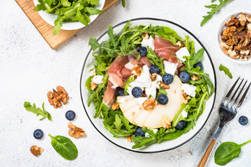 Green salad with leaves, fruit and jamon.