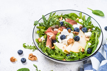 Green salad with leaves, fruit and jamon.