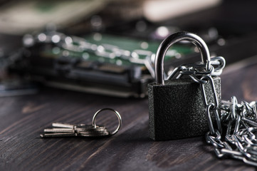 Hard disk data protection concept.Cyber security. Laptop with padlock and chain on table, closeup.Security lock on computer disk - computer security concept.