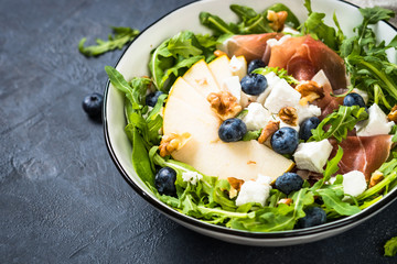 Green salad with leaves, fruit and jamon.