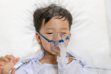 A patient boy is sick flu, He has difficulty breathing Therefore, a doctor giving medicine by a...