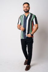 Full body shot of young bearded Indian man giving thumbs up
