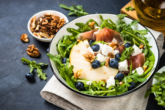 Green salad with leaves, fruit and jamon.
