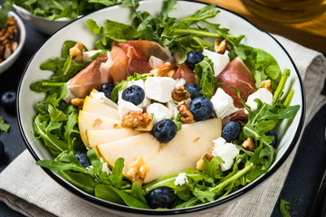 Green salad with leaves, fruit and jamon.