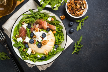 Green salad with leaves, fruit and jamon.