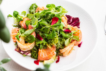 Healthy Salad. Recipe for fresh seafood. Grilled shrimps, prawns, fresh salad lettuce and avocado slices. Healthy Eating. White background. Horizontal photo.