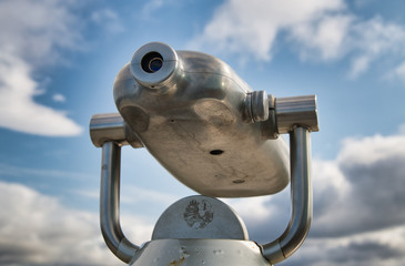 Binocular with city view and sky on the background