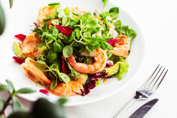 Healthy Salad. Recipe for fresh seafood. Grilled shrimps, prawns, fresh salad lettuce and avocado slices. Healthy Eating. White background. Horizontal photo.