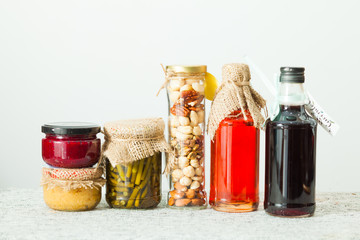 Homemade sauce, seasoning and berry syrup on white table.