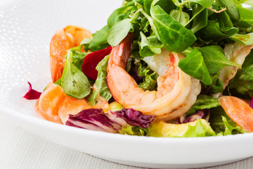 Healthy Salad. Recipe for fresh seafood. Grilled shrimps, prawns, fresh salad lettuce and avocado slices. Healthy Eating. White background. Horizontal photo.