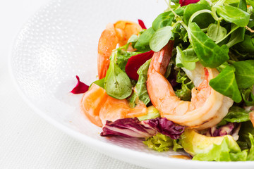 Healthy Salad. Recipe for fresh seafood. Grilled shrimps, prawns, fresh salad lettuce and avocado slices. Healthy Eating. White background. Horizontal photo.
