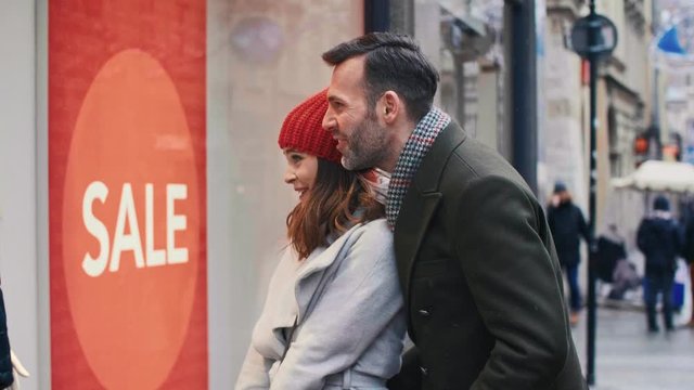 Excited woman showing something in the shop window