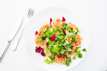 Healthy Salad. Recipe for fresh seafood. Grilled shrimps, prawns, fresh salad lettuce and avocado slices. Healthy Eating. White background. Horizontal photo.