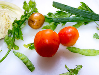 Tomatoes with another vegetables as background.