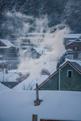 smoke comes out of the chimney. winter stove heating. frost in the village. smoke close up. snow covered roofs