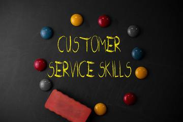 Word writing text Customer Service Skills. Business photo showcasing Aptitude to master to improve dealings with client Round Flat shape stones with one eraser stick to old chalk black board