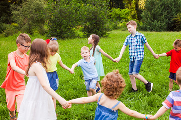 Cute little children doing circle dance outdoors