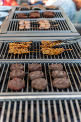 Grilling chicken skewers and hamburgers on a barbecue in a restaurant