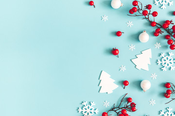 Christmas or winter composition. Snowflakes and red berries on blue background. Christmas, winter, new year concept. Flat lay, top view, copy space - 295043609