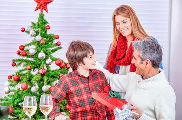 Obraz na płótnie Canvas Holidays and celebration concept - Happy family at home celebrating Christmas day