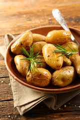 roasted potato and rosemary on wood background
